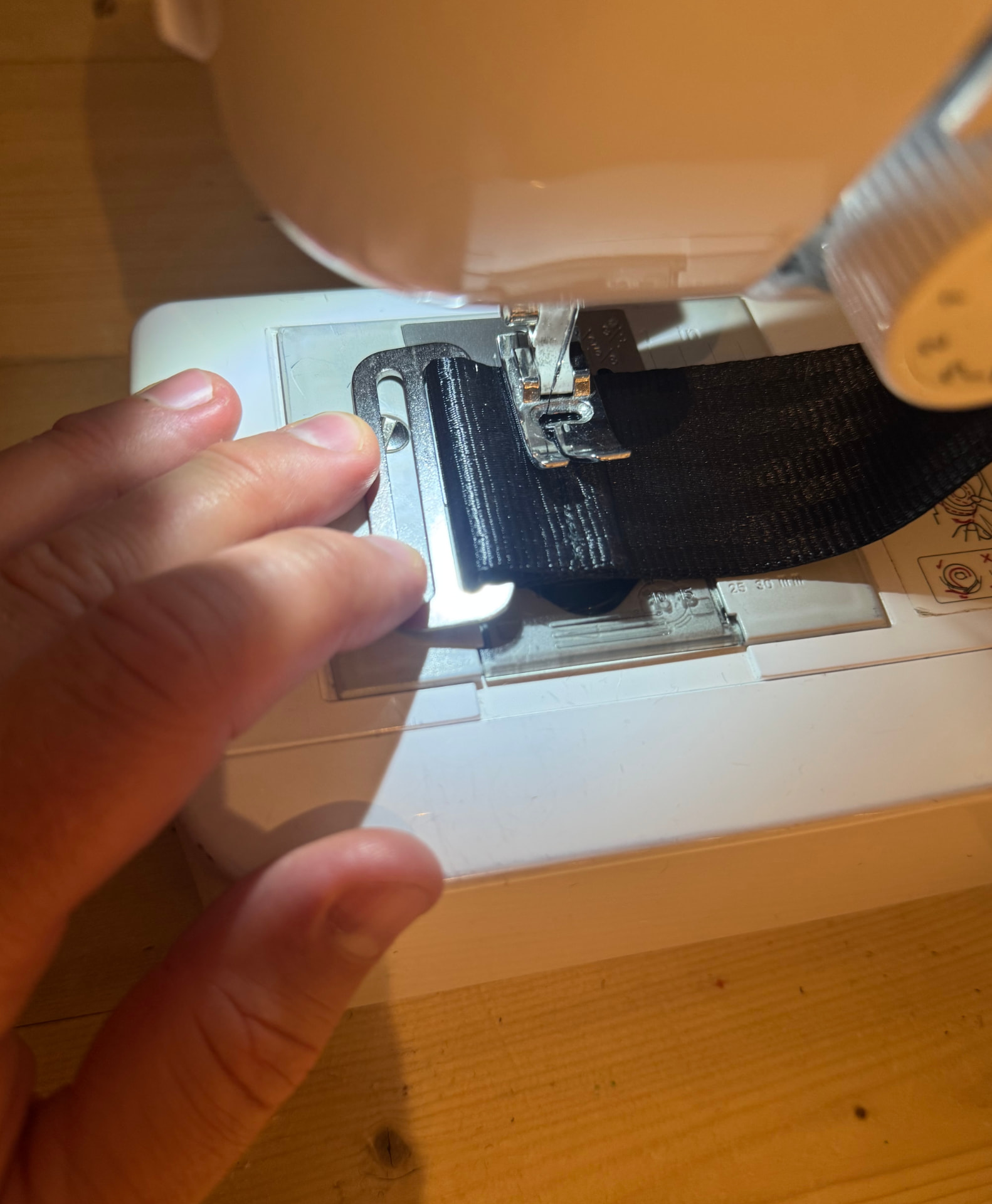 Metal buckle being stitched to webbing on a sewing machine